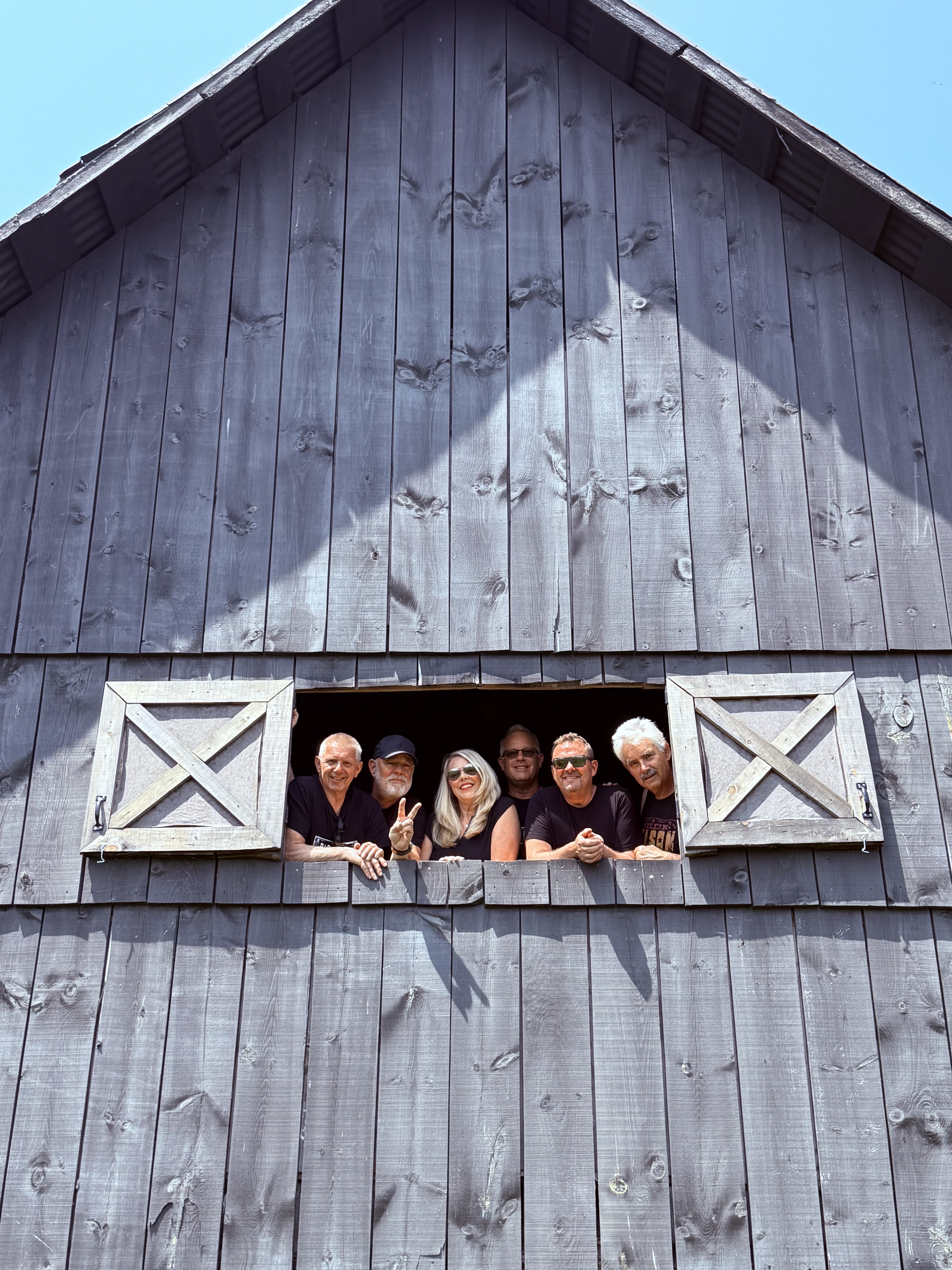 The BARN BANDits peeking out of a barn loft